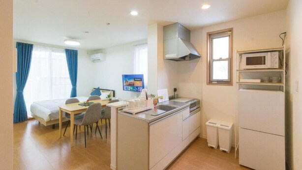 A compact hotel room with a kitchenette, a dining area, and a bed. - Best Friend (Fukuoka City Hakataku Katakasu)