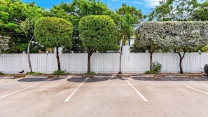 A parking lot with white picket fences and trees. - Salty Palm Retreat by Avantstay Shared Pool + Private Porch Steps to Beach + Old Town (Key West)