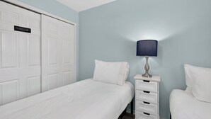A hotel room with a bed, a nightstand, a lamp, and a wardrobe. - Salty Palm Retreat by Avantstay Shared Pool + Private Porch Steps to Beach + Old Town (Key West)