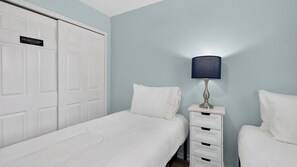 A hotel room with a bed, a nightstand, a lamp, and a wardrobe. - Salty Palm Retreat by Avantstay Shared Pool + Private Porch Steps to Beach + Old Town (Key West)