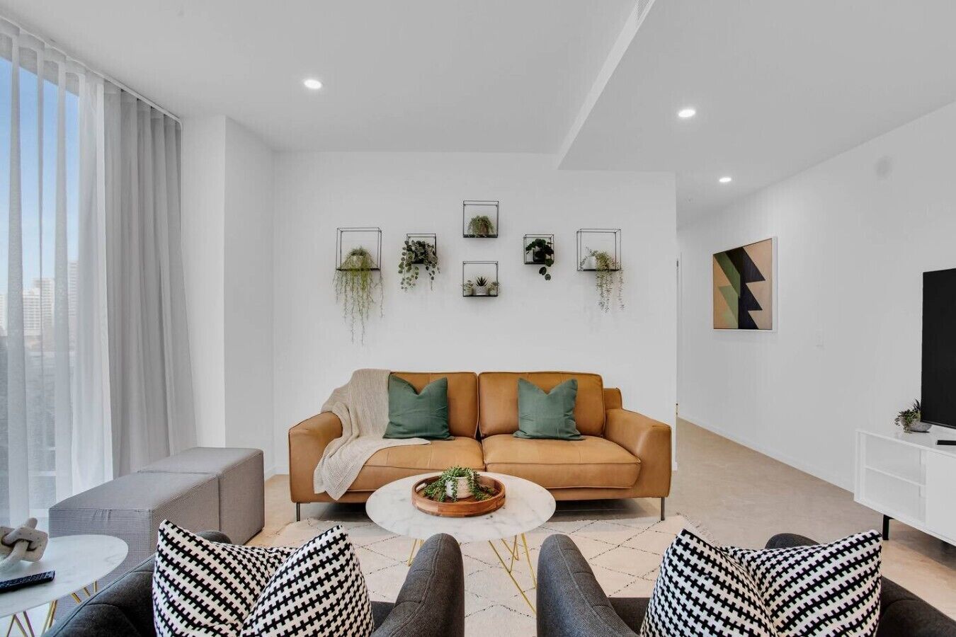 Ein modernes Wohnzimmer mit einer Couch, einem Couchtisch und gemusterten Kissen.