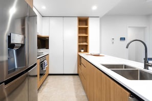 Eine moderne Küche mit Edelstahlkühlschrank, Backofen und einer Holzarbeitsplatte.