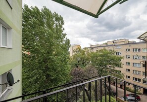 A balcony with a view of a residential area, including multi-story buildings and trees. - Elektrownia Powiśle Homely Apartment (Warszawa)