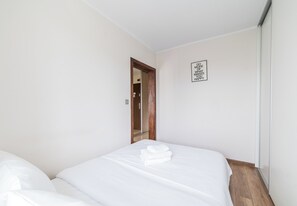 Ein Hotelzimmer mit zwei Betten, einer Holztür und einem motivierenden Zitat an der Wand.