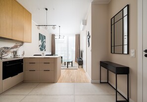 Eine moderne Küche mit eingebautem Ofen, ein Essbereich mit Tisch und Stühlen und ein großes Fenster für natürliches Licht.