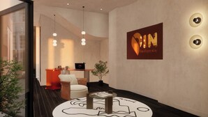 A modern interior with a reception desk, a seating area, and a wall-mounted sign. - PIN GEM Boutique (Ho Chi Minh City)