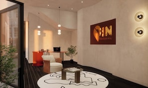 A modern interior with a reception desk, a seating area, and a wall-mounted sign. - PIN GEM Boutique (Ho Chi Minh City)