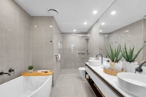 A modern bathroom with a bathtub, two sinks, a shower, and a toilet. - Lv 14 Stunning 2 Brm Apt with Skyline Views (Broadbeach)