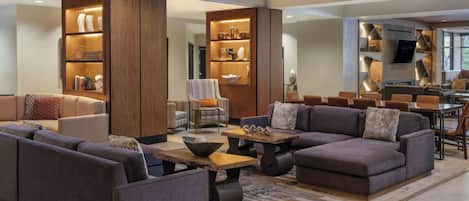 A modern lounge area with sofas, a coffee table, and built-in shelving with decorative items.