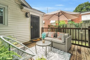 A patio with a wicker sofa, a round table, and a hammock. - Cozy Modern Nook Near Downtown - Comfortable Home Away From Home (Montgomery)