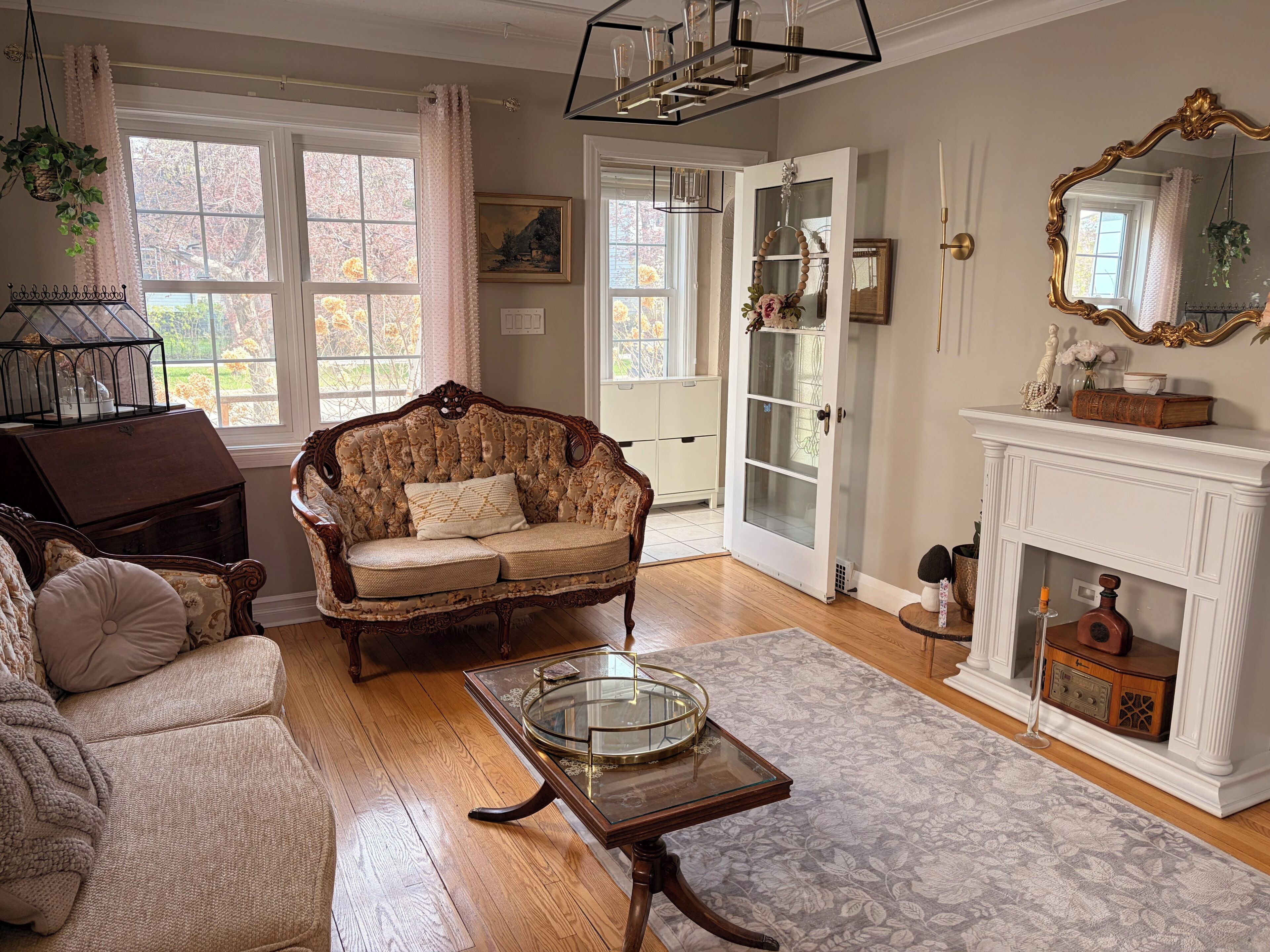 A traditional living room with a sofa, a glass coffee table, and a fireplace.