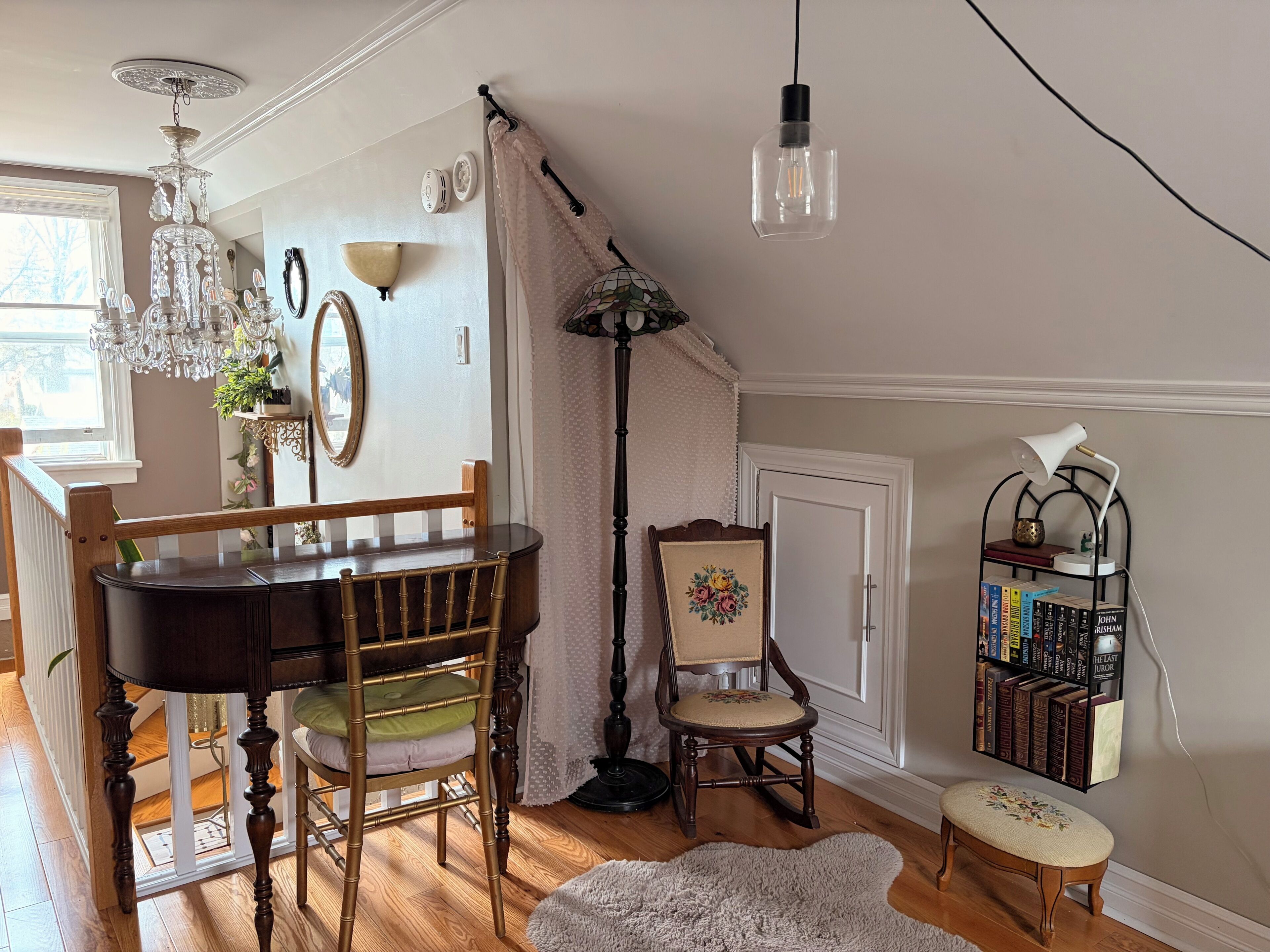 Ein Zimmer mit einem Holztisch, einem Klavier, einem Bücherregal und einer Lampe.