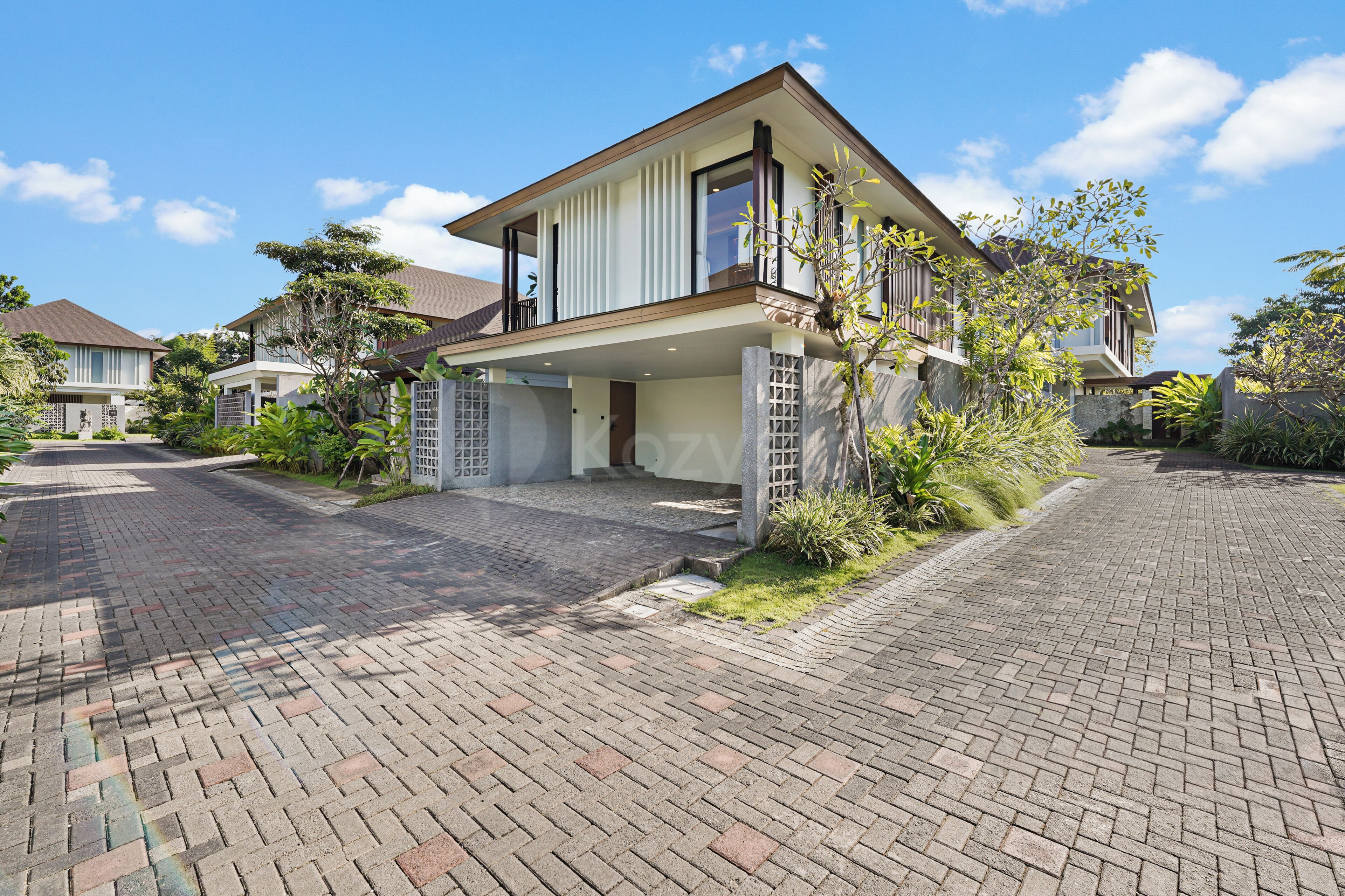 A modern two-story house with a covered entrance and a paved driveway.