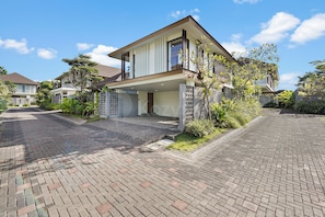 A modern two-story house with a covered entrance and a paved driveway. - Arcasena Villa by Kozystay - Jimbaran (Badung)