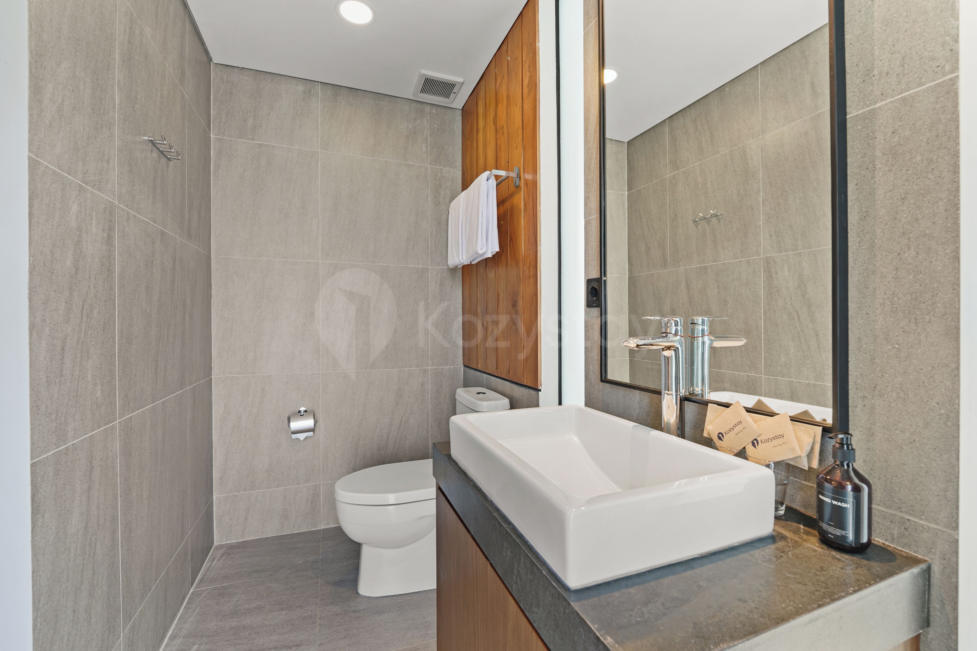 A modern bathroom with a large bathtub, a toilet, and a shower area.