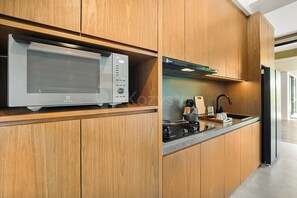 A modern kitchen with wooden cabinets, a built-in microwave, and a stove.