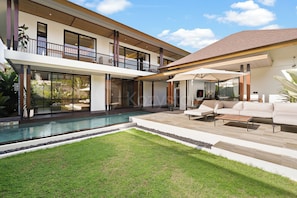 A modern two-story house with a swimming pool, outdoor seating, and a large balcony. - Arcasena Villa by Kozystay - Jimbaran (Badung)