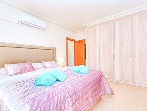 A hotel room with a bed, a wardrobe, and an air conditioning unit. - LOS PINOS - VILLA 7 by Interhome (El Carmoli)