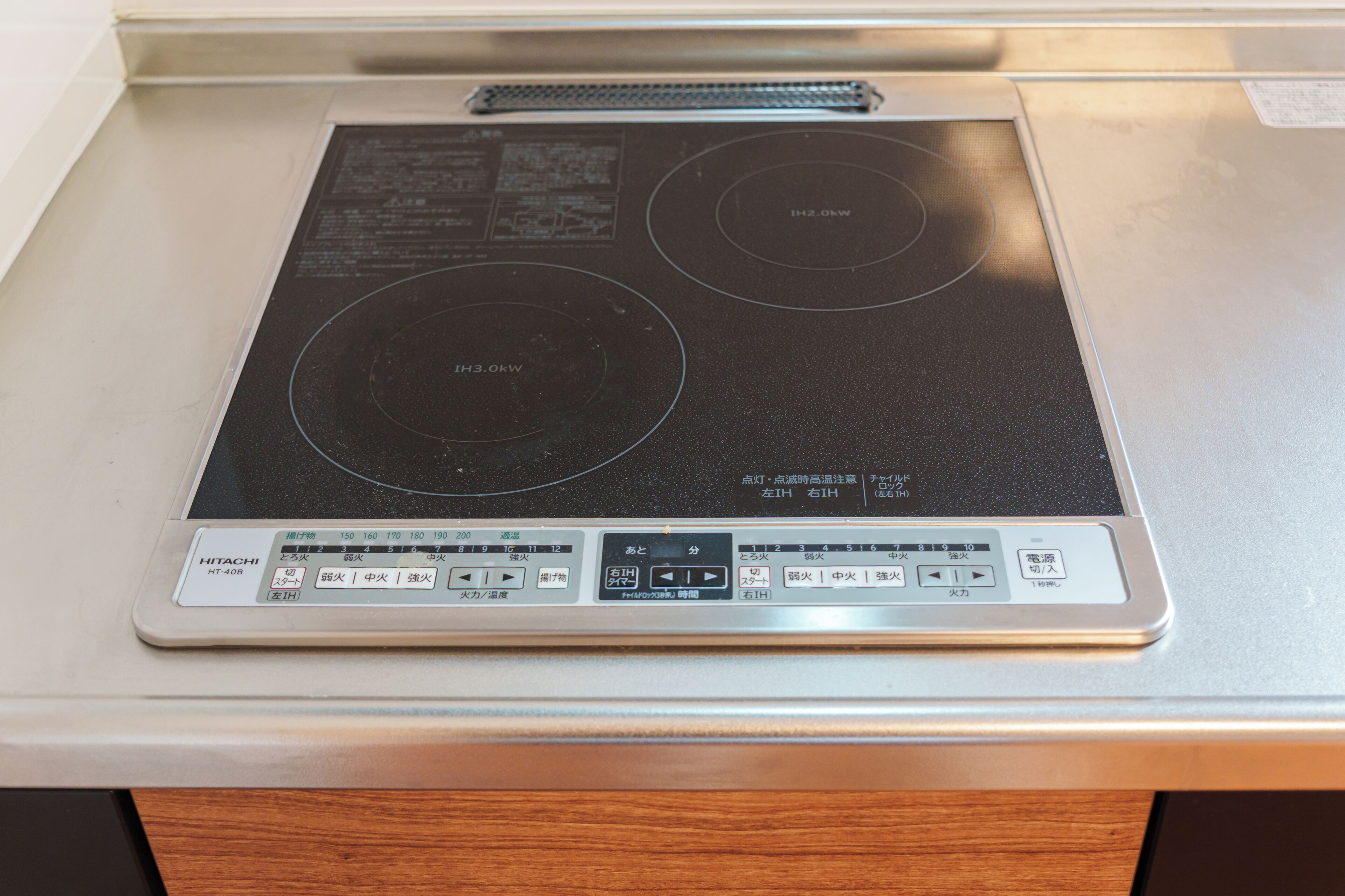 A kitchen with an induction cooktop and a control panel.