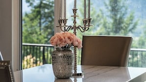 A dining table with a vase of flowers and a candle holder.