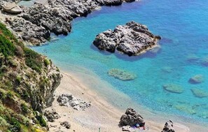 A coastal landscape with clear blue waters, rocky formations, and a sandy beach. - Gorgeous apartment in Saline Joniche with WiFi (Saline Joniche)