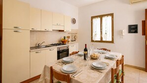 Uma cozinha com área de jantar posta para uma refeição.