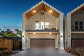 A two-story house with a garage, a balcony, and a wooden roof. - Spacious 4-bedroom house in Houston Texas Hot tub/ Play room. (Houston)