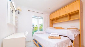 Un dormitorio con cama, escritorio y armario.