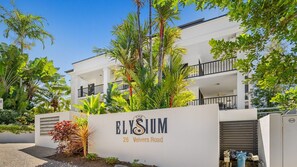 A modern building with a sign reading 'Elysium 26 Veivers Road.' - Palm Cove Studio with King Bed and Pool | Oliva Tides Studio (Palm Cove)