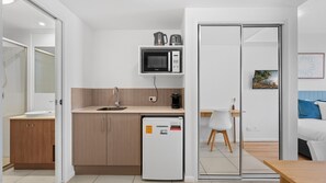 Une petite cuisine équipée d’un four à micro-ondes, d’une machine à café et d’un petit réfrigérateur.