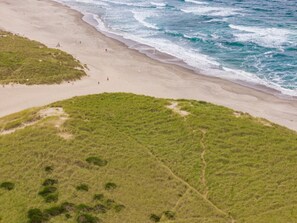 A beach with a grassy area and a sandy shoreline. - Kiwanda Cottage - Steps to the beach - Dogs OK (Pacific City)