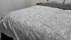 Une chambre à coucher avec un lit, une fenêtre avec des stores et une porte blanche.