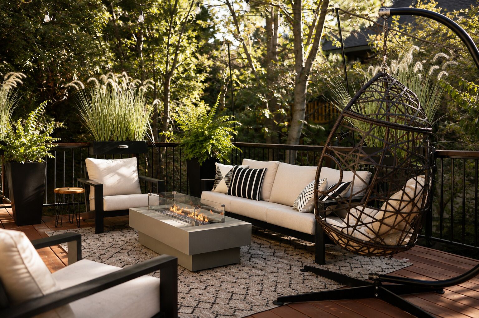 An outdoor seating area with a sofa, chairs, a fire pit, and a hanging swing.