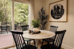 A round table with four chairs, a vase with greenery, and a framed picture on the wall. - EV charger, hot tub and A/C Cozy 3-bedroom cabin in charming Lake Arrowhead (Lake Arrowhead)
