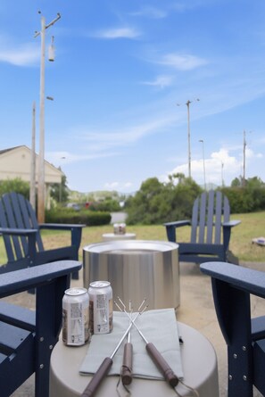 A round table with chairs, a metal container, and two cans of beer. - Mins to RRG | Hot Tub, Game Room, Fire Pit (Stanton)