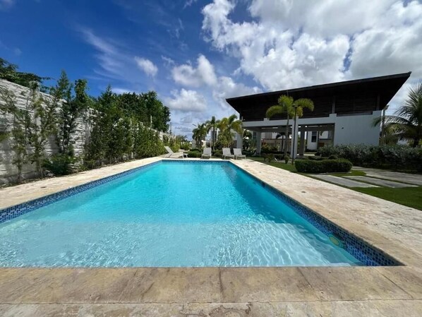 Una piscina con un edificio moderno al fondo.