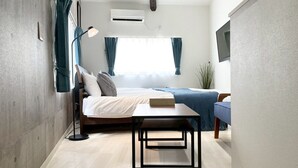 A modern bedroom with a bed, bedside table, and a desk. - Neo Universal 02 (Osaka, Konohana Ward, Nishikujo)