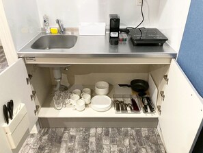 A compact kitchen with a sink, a coffee maker, and a portable heater on the countertop. - Neo Universal 02 (Osaka, Konohana Ward, Nishikujo)