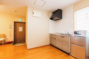 A compact kitchen with a microwave, sink, and wooden cabinets. - Just a short walk from the Shinsaibashi Glico Sign (1 min), Dotonbori (30 seconds), Kuromon Market, Namba Station, Dotonbori, and Ran no Kaku (Osaka)