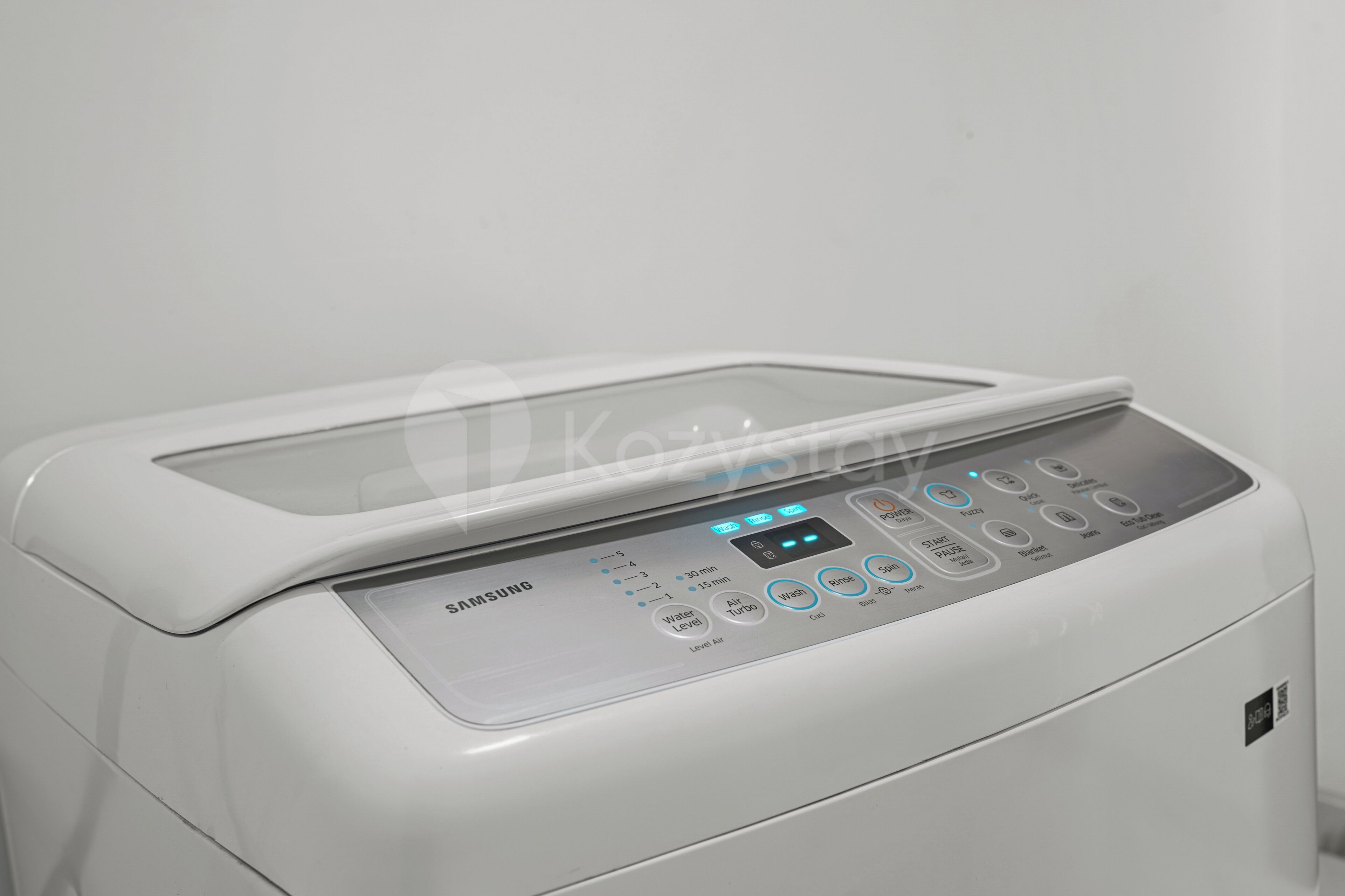 A white Samsung washing machine with a control panel featuring various buttons and a digital display.
