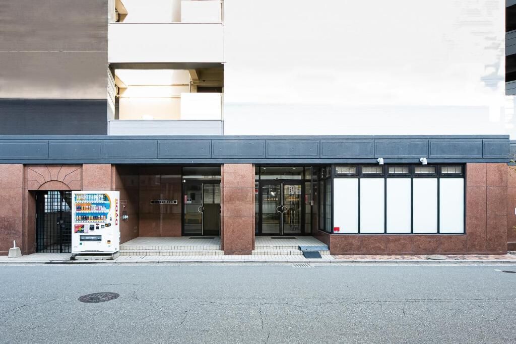 A building with a modern entrance, a vending machine, and a clear glass facade.