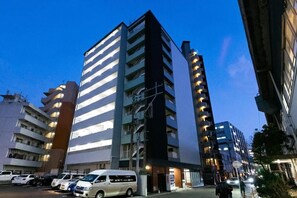 Um edifício de vários andares com um estacionamento à frente.