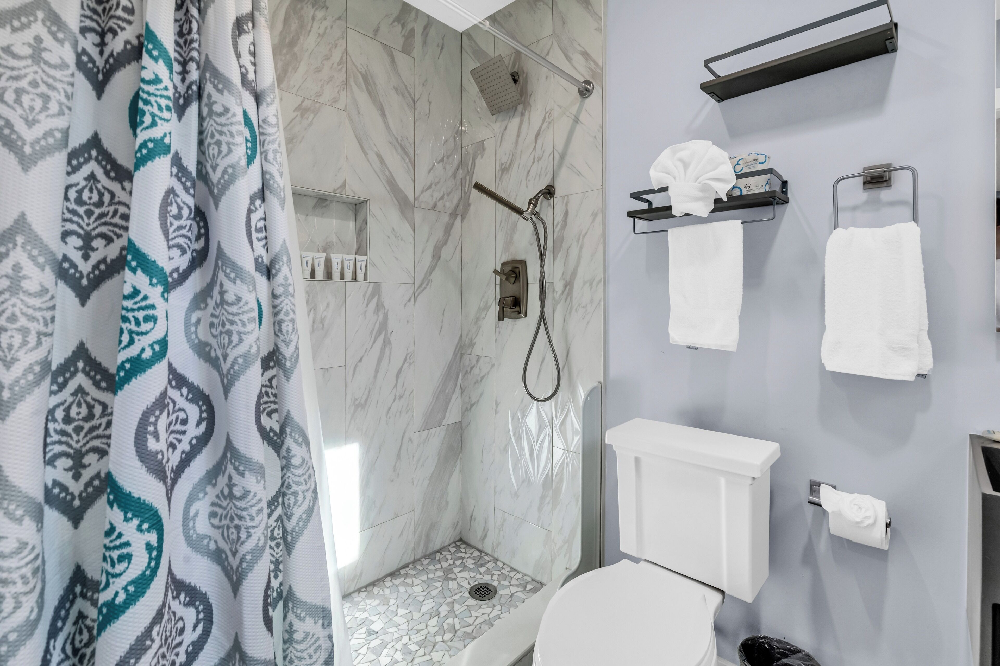 Een badkamer met douche, toilet en handdoekrekken.