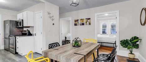 A modern kitchen with white cabinets, a stainless steel refrigerator, and a microwave.