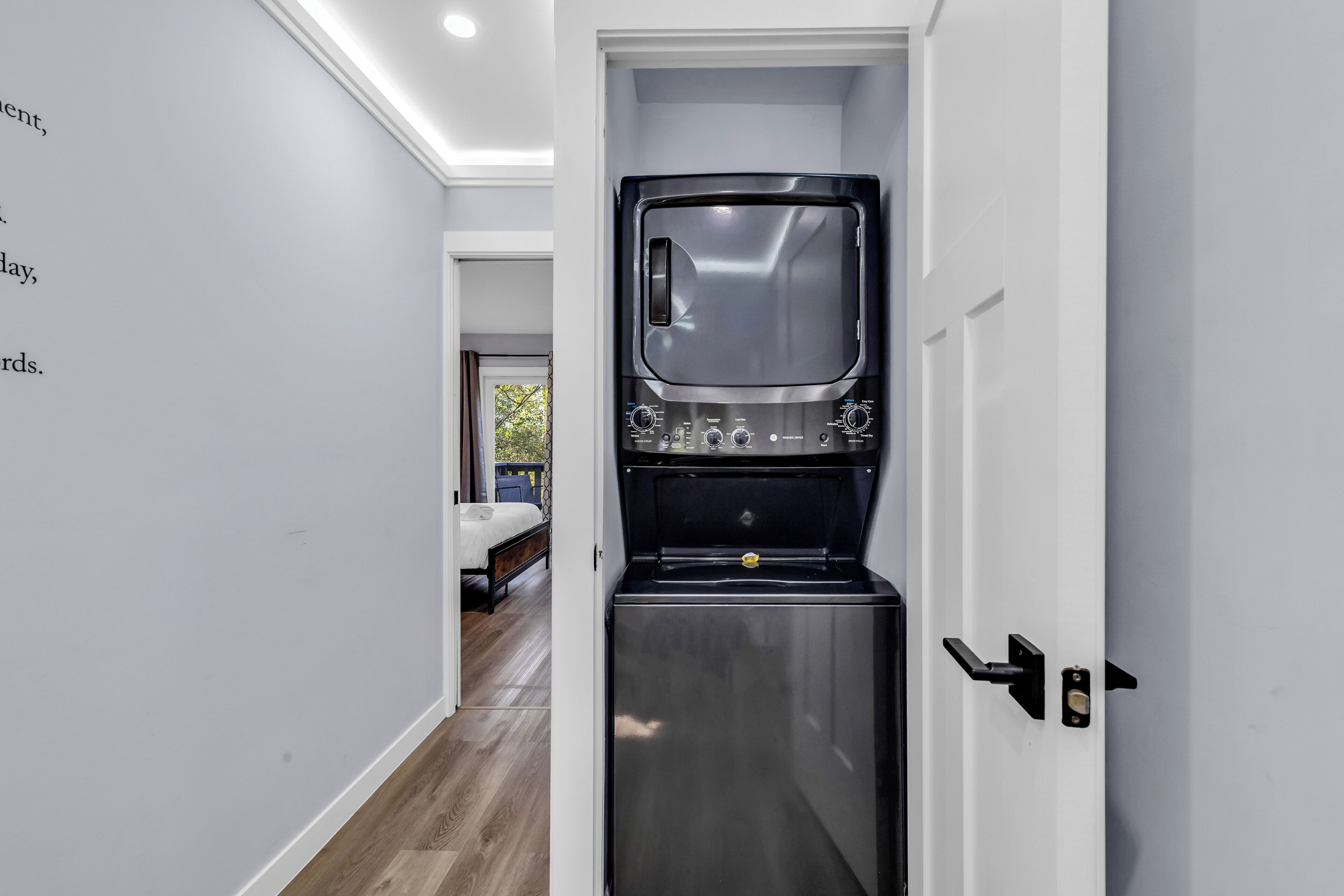 A compact kitchenette with a built-in microwave and oven, a small refrigerator, and a door with a handle.