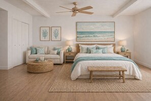 A bedroom with a bed, two nightstands, a ceiling fan, a large beach-themed painting, and a wicker side table. - Hale Puka La, Luxury Oceanview for 8, Beach Access (Princeville)