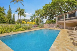 A swimming pool with a stone deck, surrounded by tropical plants and trees. - Hale Puka La, Luxury Oceanview for 8, Beach Access (Princeville)