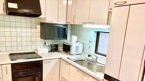 A compact kitchen with white cabinets, a microwave, a coffee maker, and a dishwasher. - Neo Universal 04 (Osaka, Konohana, Nishikujo)