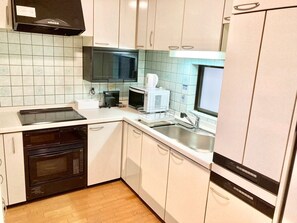 A compact kitchen with white cabinets, a microwave, a coffee maker, and a dishwasher. - Neo Universal 04 (Osaka, Konohana, Nishikujo)