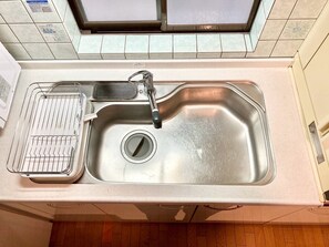 A kitchen sink with a faucet, a strainer, and a drain cover. - Neo Universal 04 (Osaka, Konohana, Nishikujo)